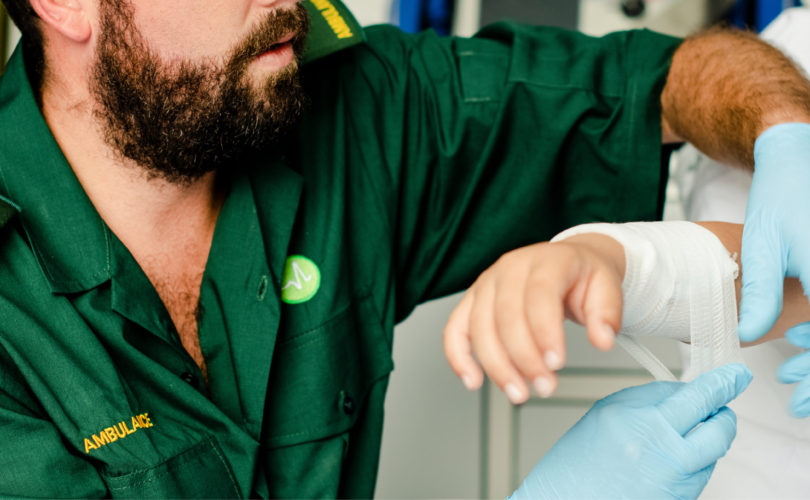 arm injury being wrapped in gauze by paramedic