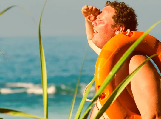 sunburnt man on a hot summer day at the beach with a floatation device